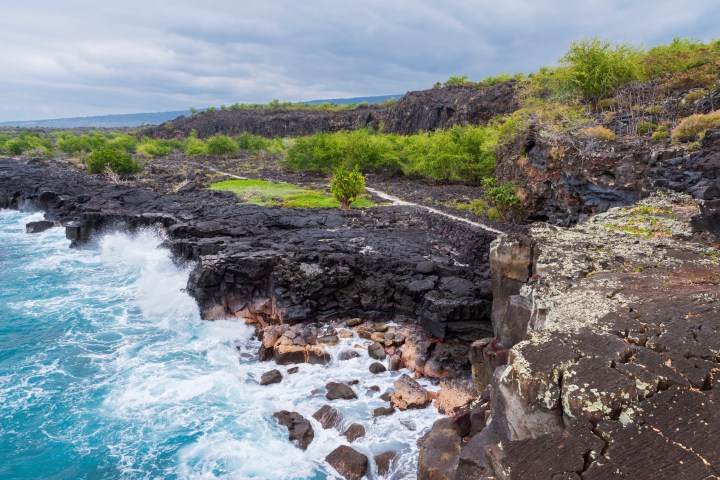 a person sitting on a rock next to water